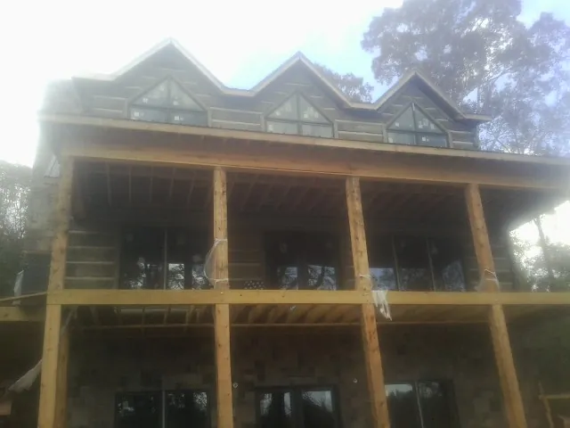 Dormers and porch framing on a large log home under construction — Roof Coating work by our crew in Toutle