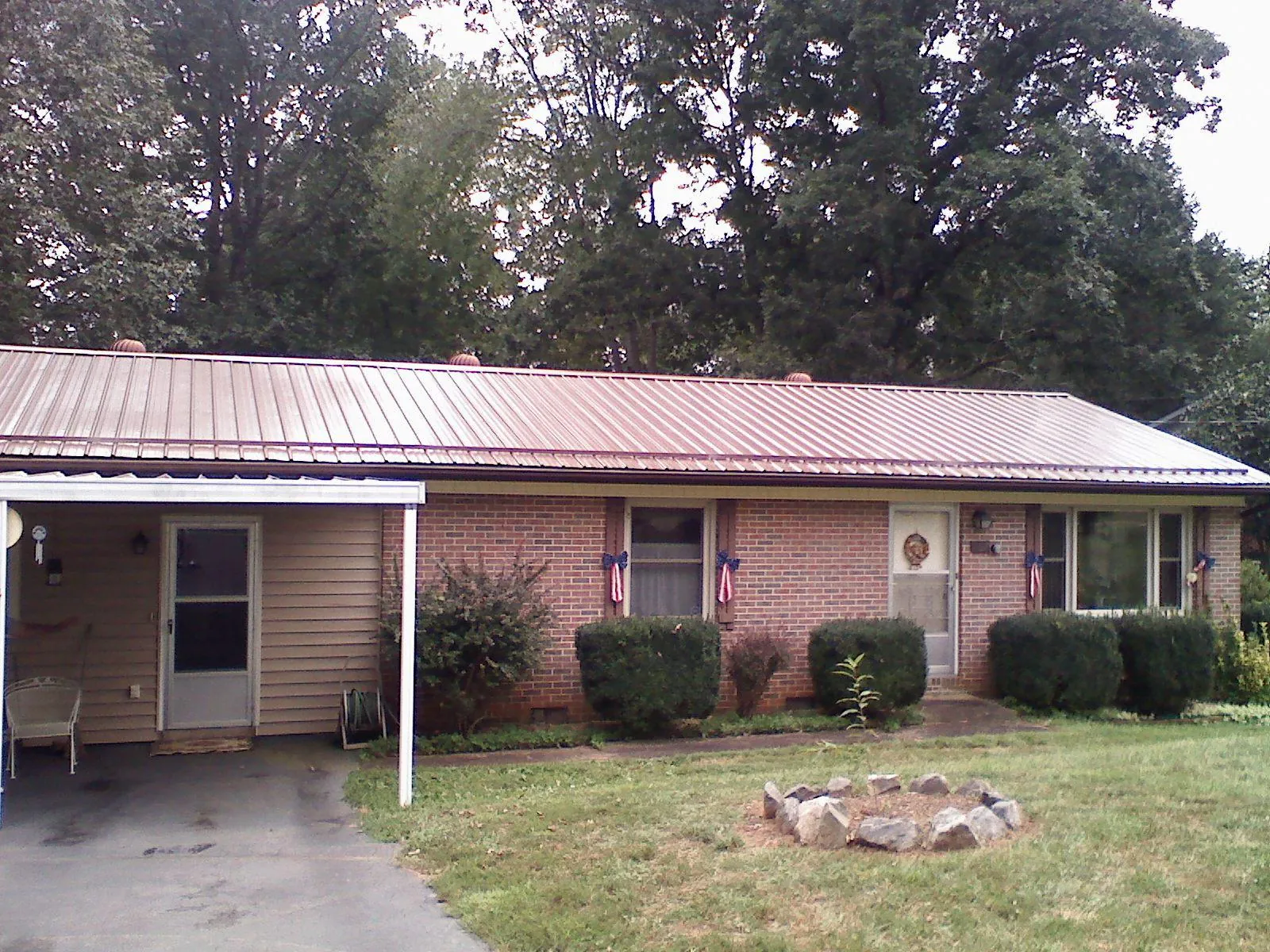 Bronze metal roof and carport on a brick ranch home — Roof Repair work by our crew in Toutle